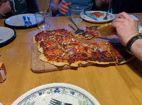 Stoltz family pizza on a wooden board, sliced and ready to eat